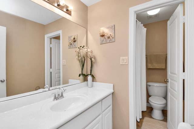 bathroom with wood finished floors, vanity, and toilet