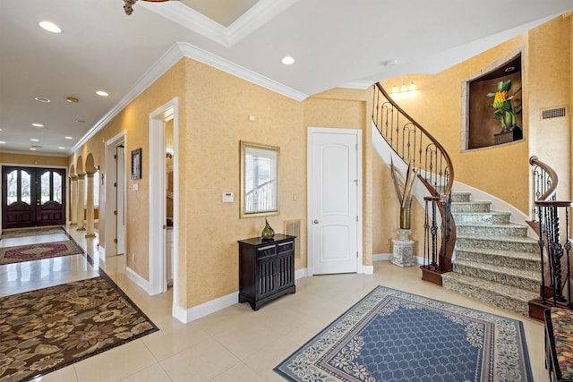 entryway with crown molding, baseboards, visible vents, and a healthy amount of sunlight