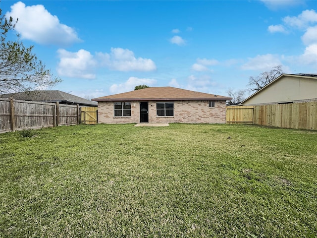 8611 Deep Valley Dr, Houston, TX 77044 - rear view of property with a yard, brick siding, and a fenced backyard
