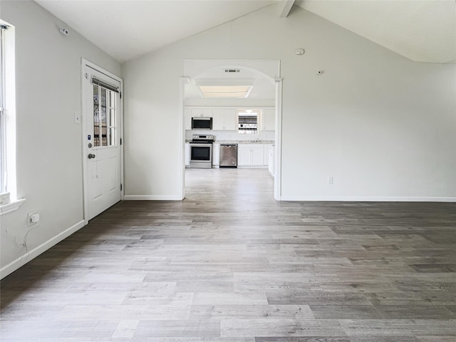 8611 Deep Valley Dr, Houston, TX 77044 - interior space with lofted ceiling with beams, light wood finished floors, visible vents, and baseboards
