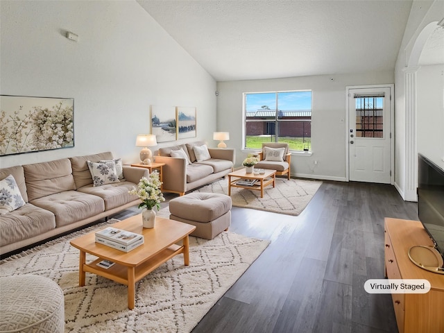 8611 Deep Valley Dr, Houston, TX 77044 - living room featuring baseboards, arched walkways, vaulted ceiling, and wood finished floors