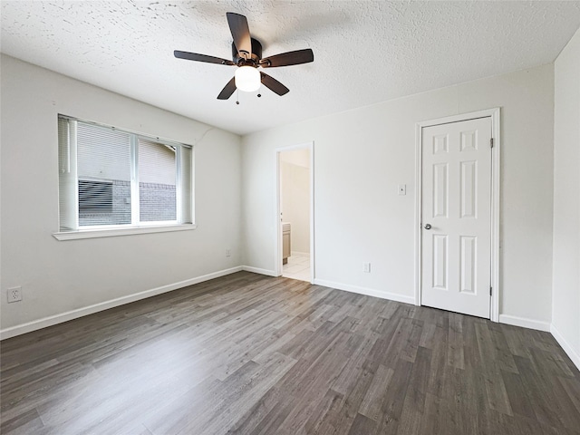 8611 Deep Valley Dr, Houston, TX 77044 - unfurnished bedroom featuring a textured ceiling, wood finished floors, a ceiling fan, baseboards, and ensuite bath