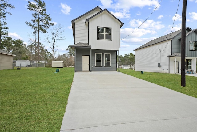 view of front facade featuring board and batten siding, a shingled roof, and a front lawn