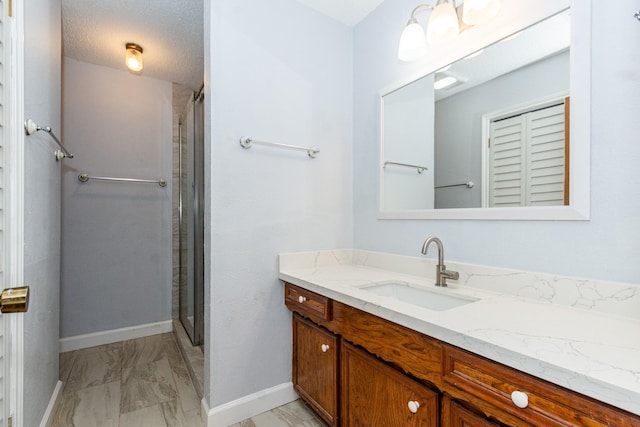 full bath with marble finish floor, baseboards, a shower, and vanity