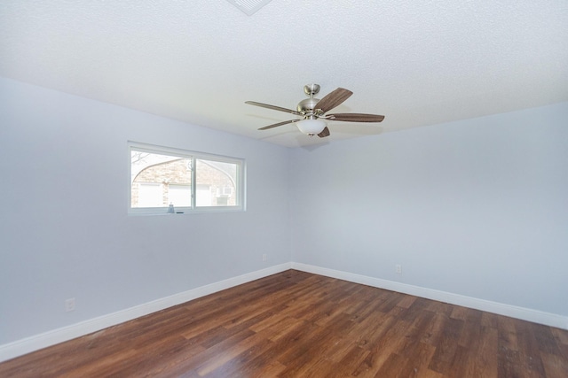 spare room featuring a ceiling fan, dark wood-style flooring, a textured ceiling, and baseboards