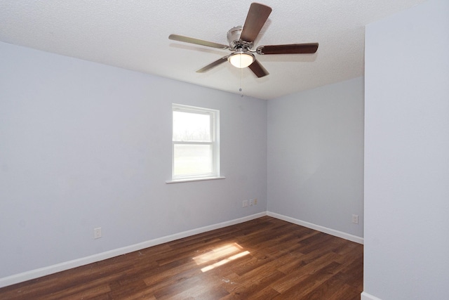 spare room featuring dark wood-style floors, ceiling fan, baseboards, and a textured ceiling