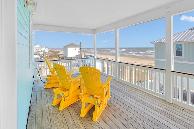 wooden terrace with a view of the beach and a water view