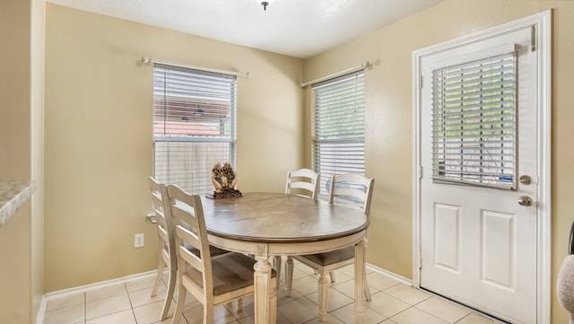 dining space featuring light tile patterned flooring and baseboards