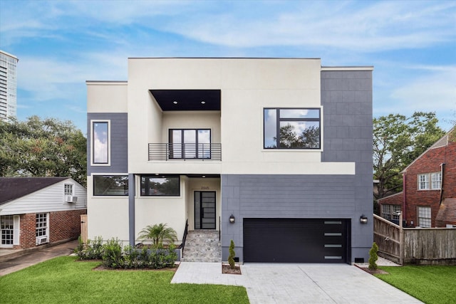 contemporary house with a balcony, driveway, a front yard, and stucco siding