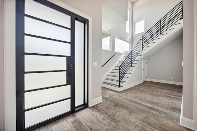 entryway featuring stairs, baseboards, and wood finished floors