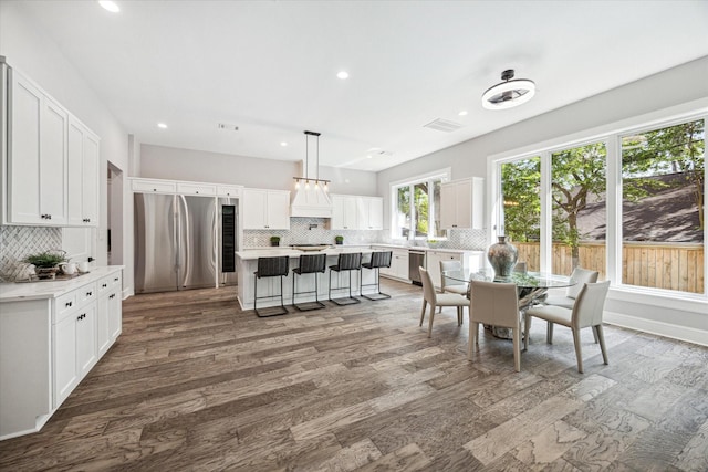 dining area with dark wood-style floors, baseboards, visible vents, and recessed lighting