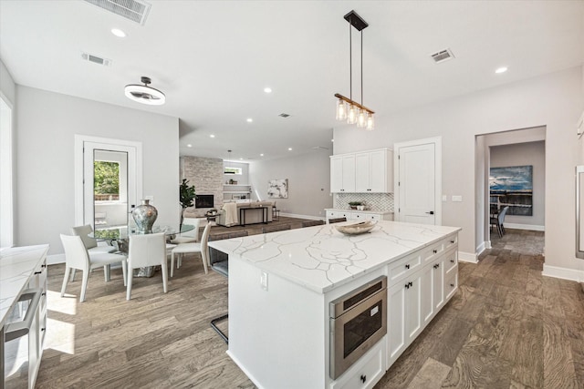 kitchen featuring white cabinets, stainless steel microwave, and visible vents