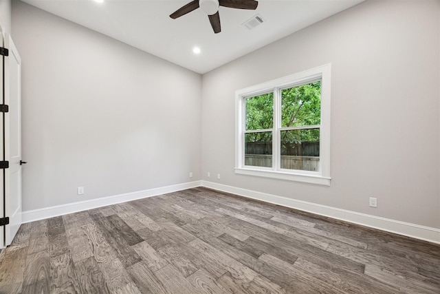 empty room with baseboards, visible vents, dark wood finished floors, and a ceiling fan