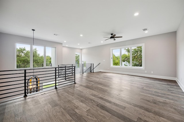 unfurnished room with baseboards, wood finished floors, visible vents, and recessed lighting