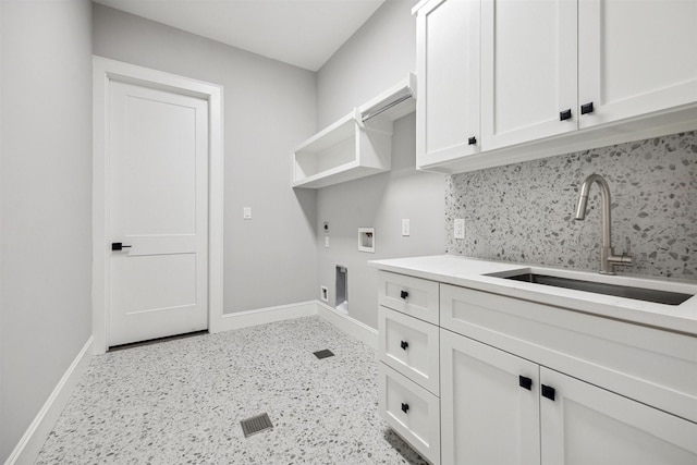 laundry area with cabinet space, baseboards, electric dryer hookup, washer hookup, and a sink