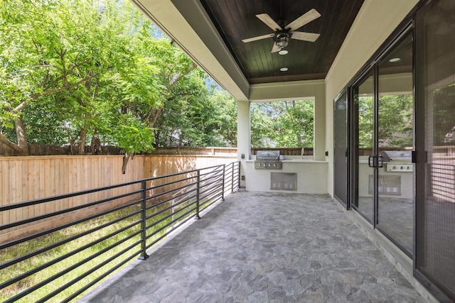 view of patio / terrace featuring a grill, fence, an outdoor kitchen, and a ceiling fan