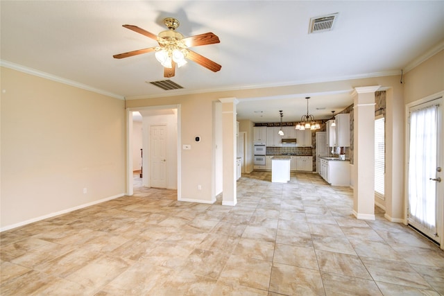 unfurnished living room with ornate columns, visible vents, and ornamental molding