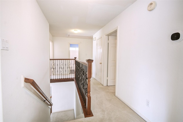 corridor featuring carpet floors, attic access, and an upstairs landing