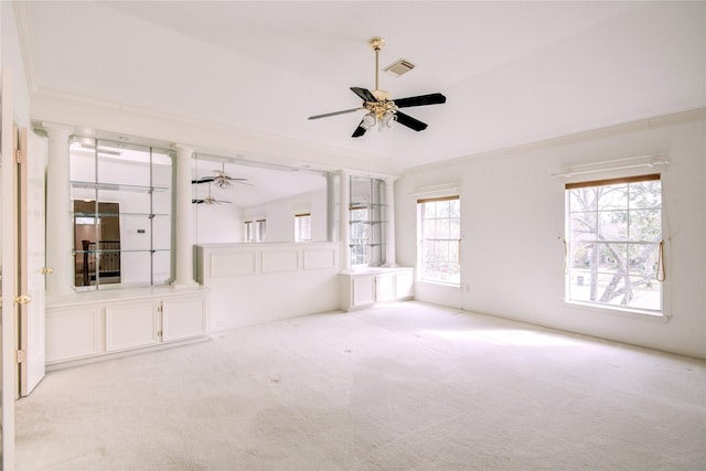 carpeted spare room with crown molding, ornate columns, visible vents, and a ceiling fan