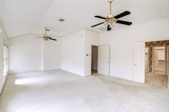 unfurnished room with lofted ceiling, visible vents, light colored carpet, ornamental molding, and ceiling fan