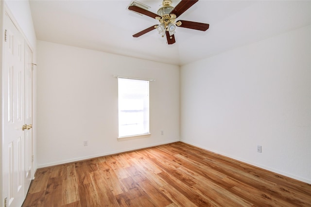 unfurnished room with wood finished floors, a ceiling fan, and baseboards