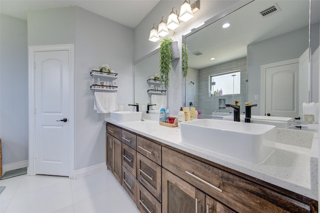 full bathroom featuring double vanity, a sink, tiled shower, baseboards, and tile patterned floors