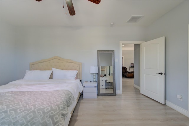 bedroom featuring ceiling fan, light wood finished floors, visible vents, and baseboards