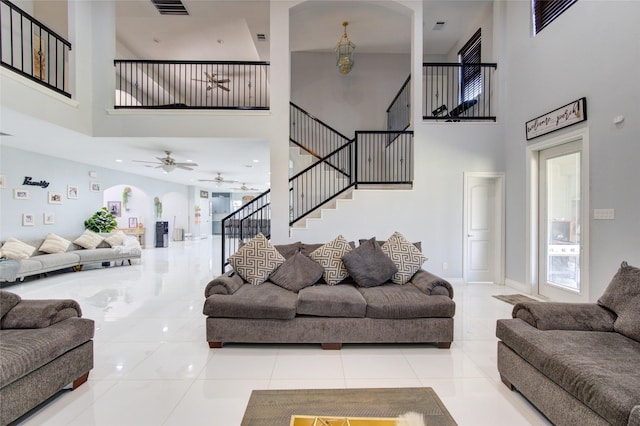 living area with baseboards, stairway, and tile patterned floors