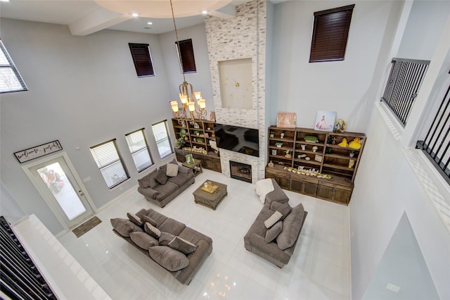 tiled living area featuring a towering ceiling, a fireplace, a chandelier, and recessed lighting