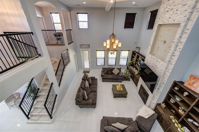 living room featuring arched walkways, a notable chandelier, stairway, a towering ceiling, and tile patterned floors