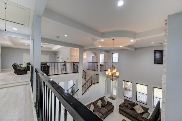 hall featuring baseboards, a towering ceiling, an inviting chandelier, an upstairs landing, and recessed lighting