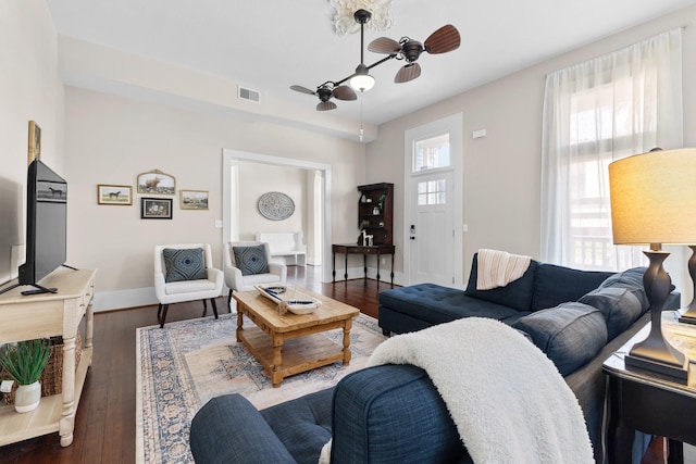 living area featuring visible vents, ceiling fan, baseboards, and hardwood / wood-style flooring