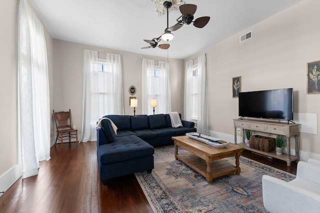 living area with ceiling fan, hardwood / wood-style floors, visible vents, and baseboards