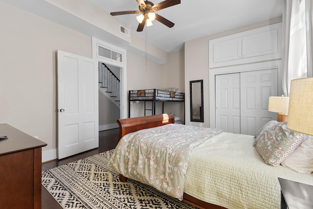 bedroom featuring a closet, visible vents, ceiling fan, wood finished floors, and baseboards