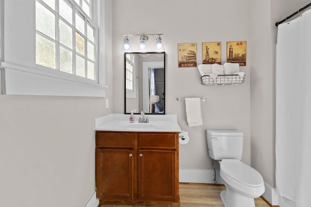 full bath featuring wood finished floors, vanity, toilet, and baseboards