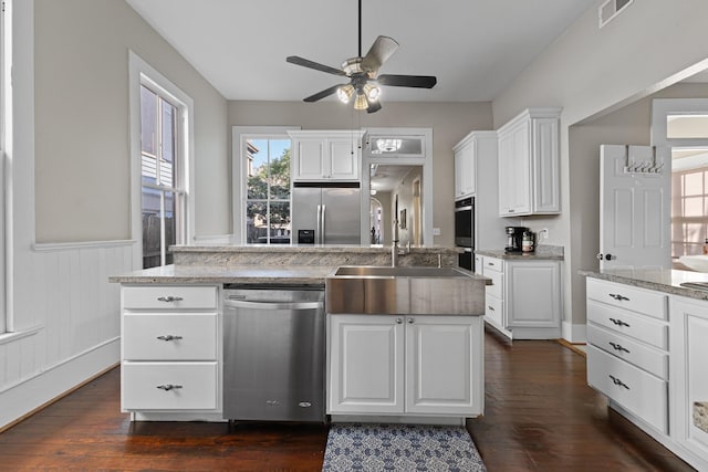 kitchen featuring visible vents, white cabinetry, appliances with stainless steel finishes, wainscoting, and dark wood finished floors