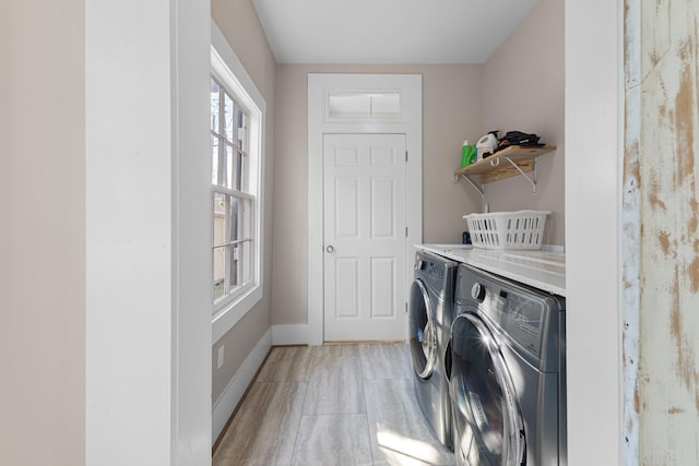 laundry room with laundry area, washer and clothes dryer, and baseboards