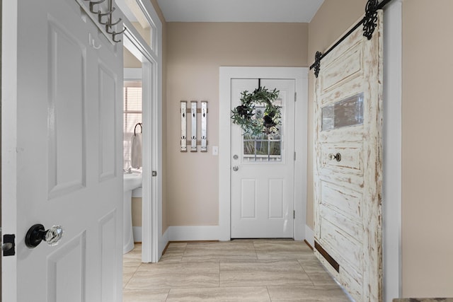 entryway featuring a barn door and baseboards