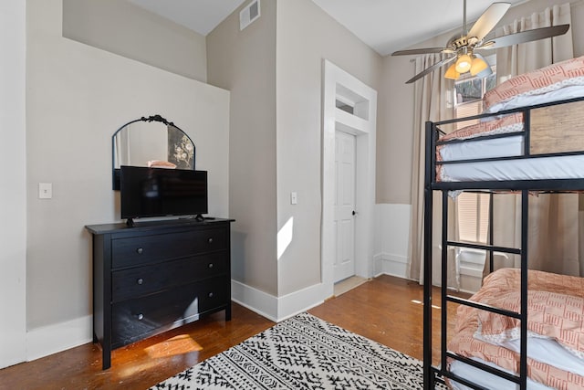 bedroom with lofted ceiling, multiple windows, wood finished floors, and visible vents