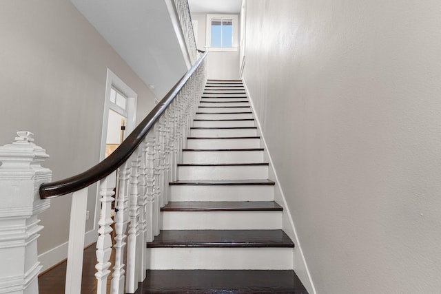 staircase with baseboards and wood finished floors