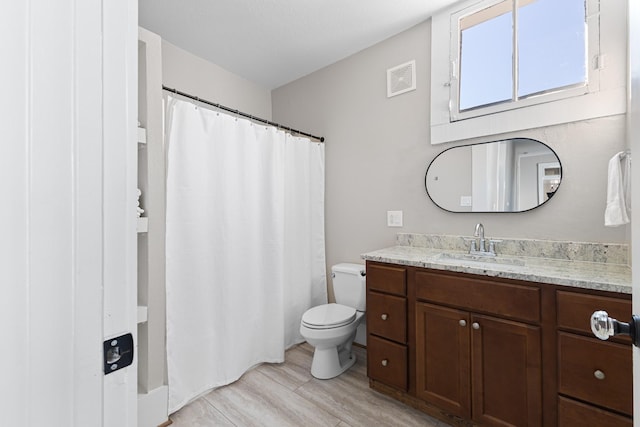 bathroom featuring toilet, a shower with shower curtain, wood finished floors, visible vents, and vanity