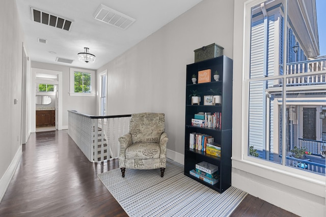 living area featuring visible vents and wood finished floors