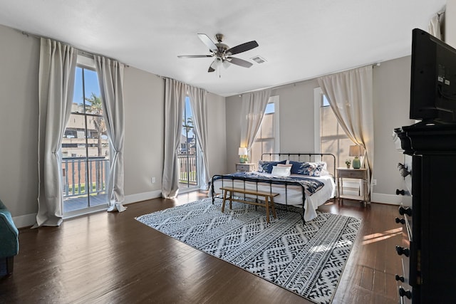 bedroom with access to outside, wood finished floors, visible vents, and baseboards