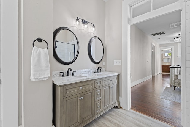 full bath featuring visible vents, a sink, and baseboards