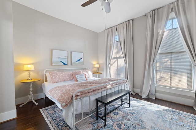 bedroom featuring wood finished floors, a ceiling fan, and baseboards