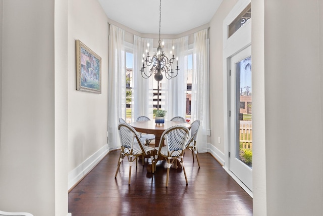 dining area featuring dark wood-style floors, a chandelier, and baseboards