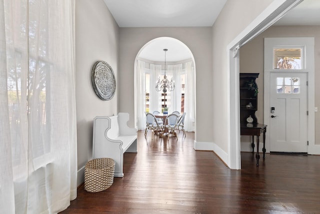 foyer featuring wood-type flooring, a chandelier, and baseboards