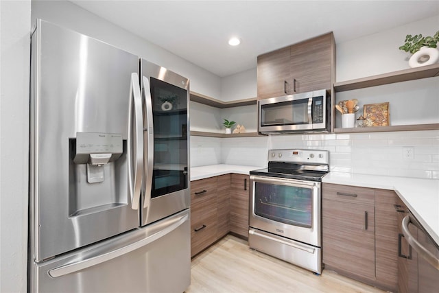 kitchen featuring stainless steel appliances, tasteful backsplash, light countertops, and open shelves