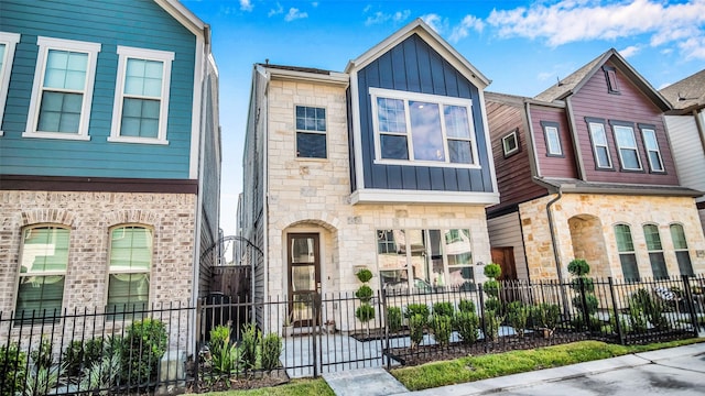 townhome / multi-family property with a fenced front yard and board and batten siding