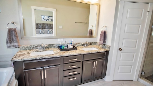 ensuite bathroom featuring connected bathroom, an enclosed shower, a sink, and double vanity